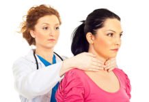 Lääkäri tunnustelee naisen kilpirauhasta käsin kaulalta.