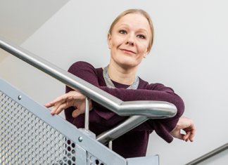 Tutkija Anna-Maija Tolppanen nojaa portaiden kaiteeseen
