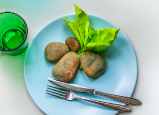 lautasella kiviä ja vihreä lautasliina salaattina