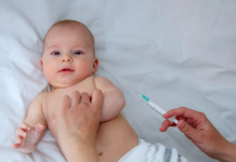 Pikkuvauva saa rokotuksen.