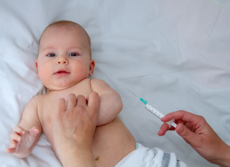 Pikkuvauva saa rokotuksen.