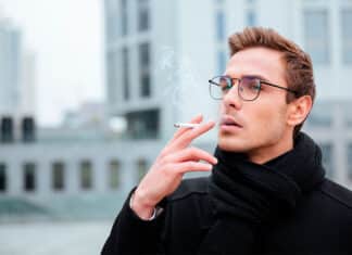nuori mies polttaa tupakkaa nautinnollisesti