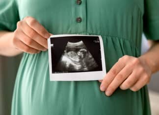 ultraäänikuva sikiöstä naisen vatsan edessä